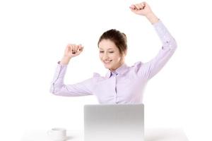 Young happy girl raising arms in front of laptop photo