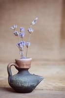 flor de lavanda en botella en mesa de madera foto