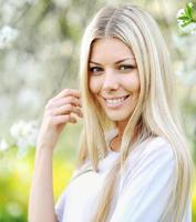 Portrait of a beautiful girl on background blooming tree photo