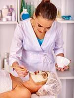 mujer de mediana edad tomar masaje facial en el salón de spa