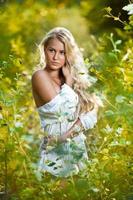 Sensual young blonde woman with white shirt in forest