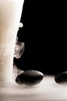 piedra de masaje spa con zarcillos flotantes de humo