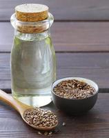 aceite de semilla de lino en botella de vidrio sobre una mesa de madera foto