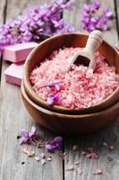 concepto de spa con sal rosa, jabón y flores foto