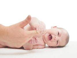 Crying small caucasian baby boy hold woman finger