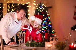 Father and daughter lighting Christmas candles photo