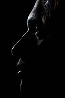 Perfil de un joven rostro masculino caucásico en la oscuridad foto