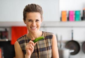 Smiling woman holding fresh cucumber