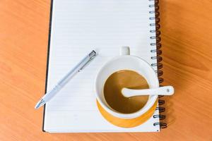 Notebook and coffee on wooden background