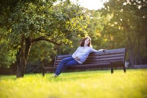 Beautiful young pregnant woman enjoying the sunset in autumn park photo