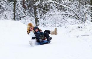 Mother and son enjoying sleigh ride on beautiful winter day photo