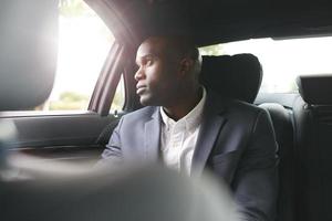 empresario africano viajando para trabajar en el automóvil de lujo foto