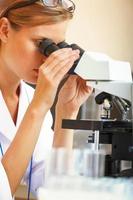 Mujer que trabaja con un microscopio.