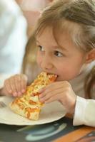 Little girl eating pizza photo