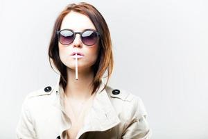 mujer de moda en abrigo y gafas de sol con cigarrillo