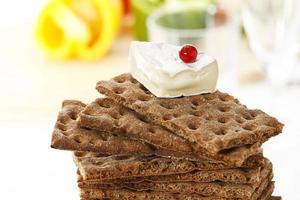Stacked wholemeal crispbread with soft cheese and currant photo