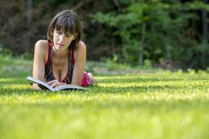 Woman Lying on the Grass While Reading a Book