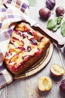 Pie with plums on the table photo