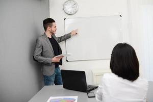 young business man or teacher showing data on white board