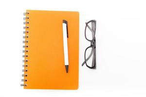 cuaderno y bolígrafo con anteojos foto