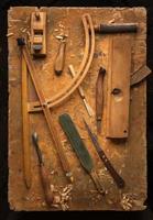 herramientas de mano de madera sobre una vieja mesa de trabajo de madera foto