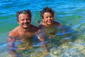 Happy swimmers dad and son in the sea