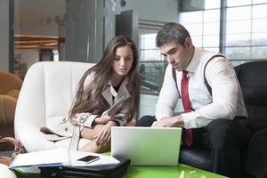 Businessman and businesswoman at meeting with laptop