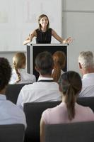 Businesswoman delivering presentation on front of a podium photo