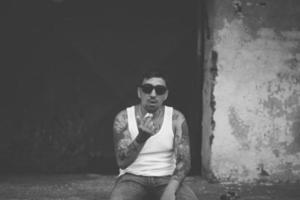 Hipster male with tattoes smoke cigarette photo