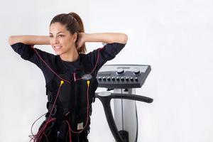 young fit woman exercise on electro muscular stimulation machine photo