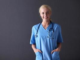 Young doctor woman with stethoscope isolated on gray background photo