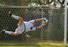 Goal keeper in mid air saving a ball photo
