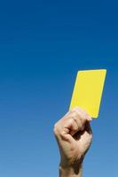 Yellow card in the hand against blue sky