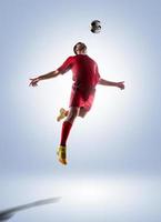 Soccer player about to headbutt the ball on white background photo