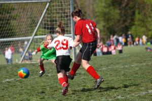 Girl Kicking Ball at Goal photo