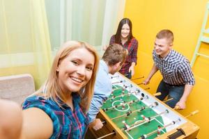 Happy friends playing table hockey