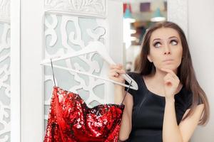 Surprised Girl Trying on Red Party Dress in Dressing Room photo