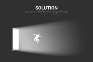Silhouette of businessman jumping out from lit door vector