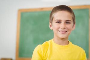 alumno sonriente sentado en un salón de clases foto