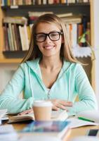 Chica estudiante feliz con libro y café en la biblioteca