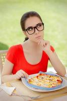 Thoughtful Woman Measures Pizza with Measure Tape