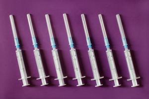 Seven syringes on purple background