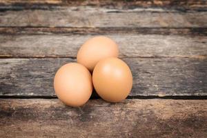 Chicken brown eggs on wooden background photo