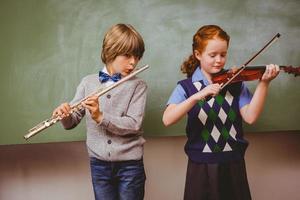 Students playing flute and violin in classroom photo