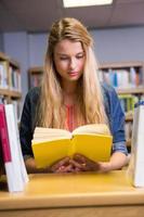 bonita estudiante estudiando en la biblioteca foto