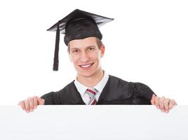 hombre graduado con cartelera blanca foto