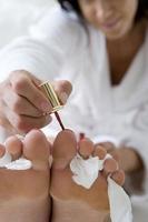 Young woman painting toe nails, close-up photo