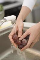 mano de persona lavando uvas foto