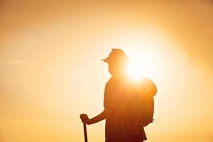 Man with hat in backlight and sunset photo
