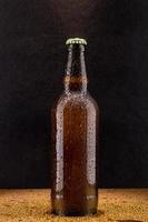 botella de cerveza fría y marrón sobre negro